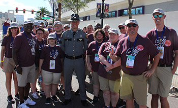 Kentucky State Police Sergeant Barrett Brewer in uniform surrounded by Kentucky athletes before the Opening Ceremonies of the 2022 Special Olympics USA Games 