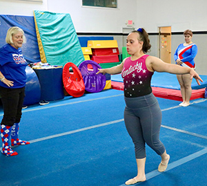 Gymnast Lee Dockins works out while coach Mary Fehrenbach looks on.