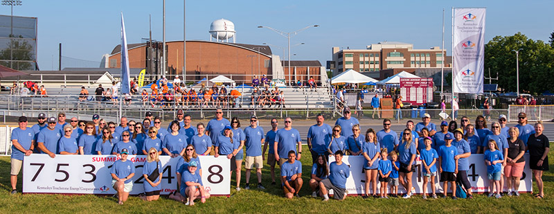 Touchstone volunteers who participated in the State Summer Games, pose for a group photo near a Touchstone banner.