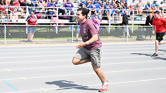 A single athlete runs from right to left ddown the track.