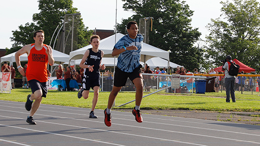 Runners sprint down the track.