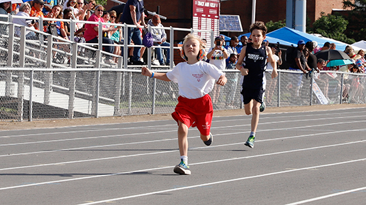 Two rung runners sprint down an outdoor track.