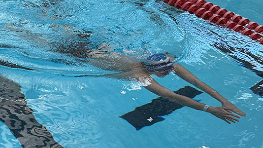 Swimmer reaches for the wall at a swim meet.