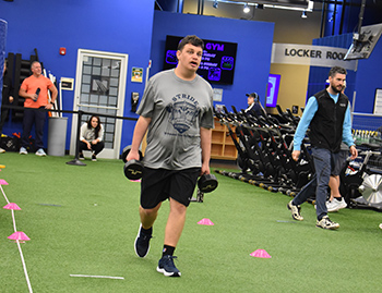 Athlete carrying weights in the Farmer's Carry event at the Fitness Competition