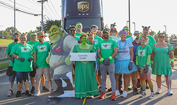 The Cummins team dressed in a Shrek theme standing in front of an 18-wheeler.
