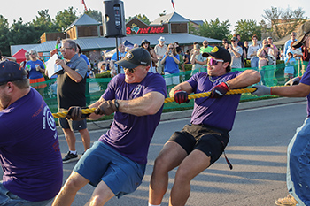 Men pulling a rope in front of Texas Roadhouse.