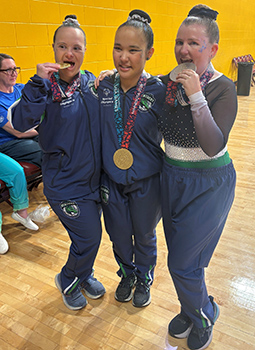 Three gymnasts with medals.