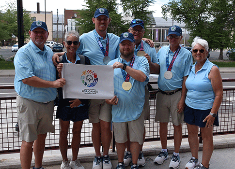 Golfers with a USA Games golf flag