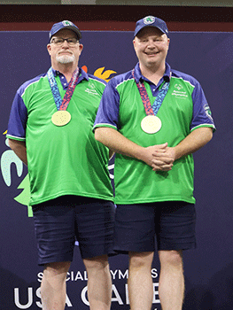 Jeff and Brett Thompson standing on top of the awards platform with their gold medals.