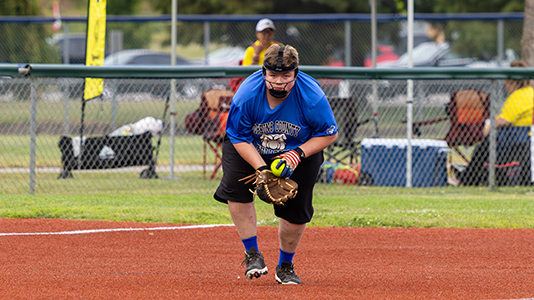Hopkins County softball player fielding a ball.