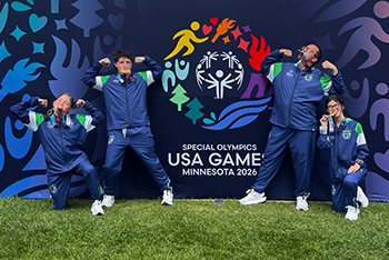 Track team in front of USA Games banner.