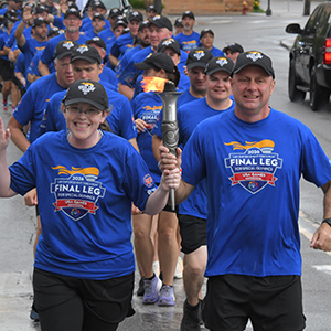 Richmond Police Chief Rodney Richardson carries the Special Olympics Flame of Hope with a Special Olympics athlete.