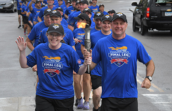 Chief Richardson and a Special Olympics athlete carrying the Special Olympics torch.